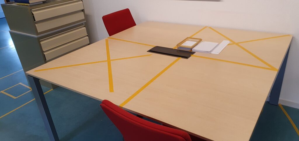 Tafels op de studiezaal met beperkte zitruimte, aangegeven middels oranje kruizen op de tafel.