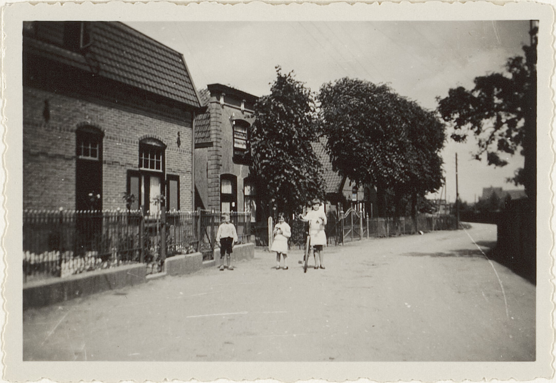 Gedeelte van de Vlierweg gezien naar het oosten met links enkele van de woningen aan de noordzijde van de weg. Op de weg staan drie kinderenTopografisch-Historische Atlas Houten, Schalkwijk en Tull en 't Waal, Cat# 41146