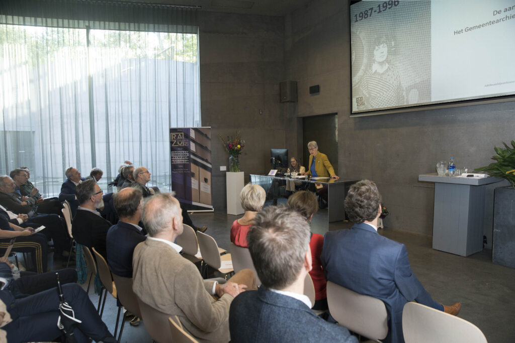 Foto 25 jaar jubileum RAZU op 15 oktober 2021 door Hans Dirksen. Genodigden luisteren aandachtig naar de toespraak van Ria van der Eerden in het Auditorium.