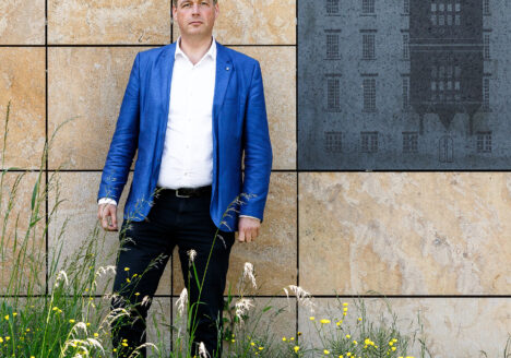 Herman Postema poserend voor de archiefbewaarplaats van het RAZU. Foto: Winfried Leeman, 2022